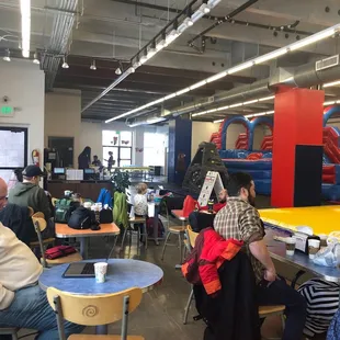 Inside area has lots of tables and chairs and a coffee machine with free coffee.