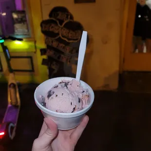 a hand holding a bowl of ice cream