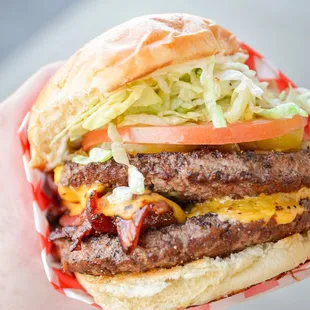 a hand holding a cheeseburger