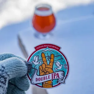 a hand holding a beer