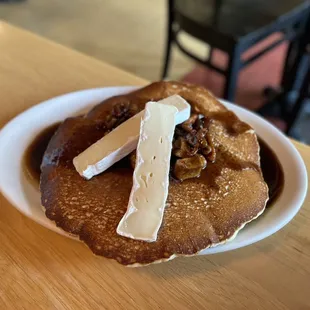 a plate of pancakes with cheese and syrup