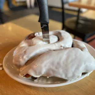 a pastry with icing and a knife