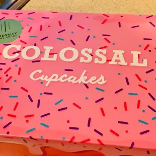 a close up of a pink cake with sprinkles