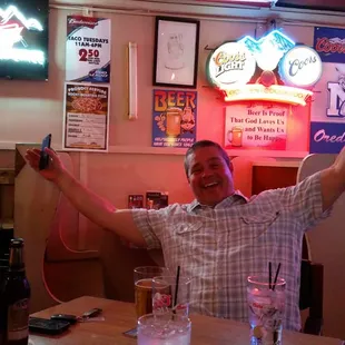 a man sitting at a table with his arms in the air