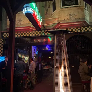people sitting at tables in front of a gas heater