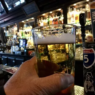 a hand holding a glass of beer