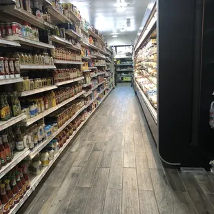 Milk/ cheese/cold cut fridge, shelves filled with great variety of canned items and jars.  A welcome upgrade.