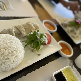 a plate of rice, meat and sauces