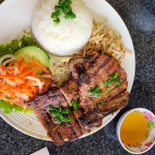 a plate of meat, rice, and vegetables