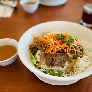 a bowl of noodles with meat and vegetables