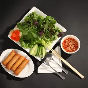 a plate of food and a bowl of dipping sauce