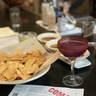 a plate of chips and a drink on a table
