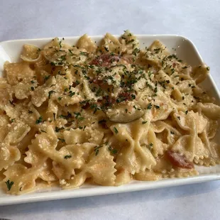 Lunch portion of bow-tie pasta with pink pepper sauce