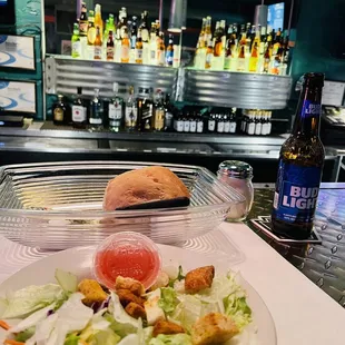 Salad with roll, backlit with the amazing bar.