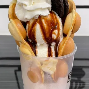 Bubble waffle and vanilla ice cream with chocolate sauce and whipped cream