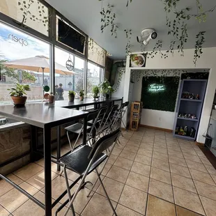 Inside area with tables overlooking the street and outside table. Instagrammy backdrop too