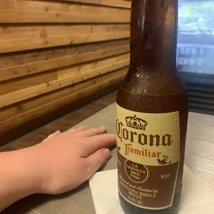 a hand reaching for a bottle of beer