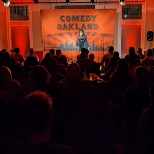 a man standing on stage in front of a crowd