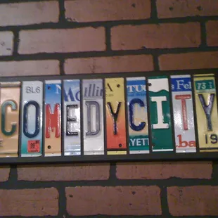 a brick wall with the word comedy on it