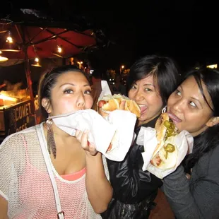 three women eating hot dogs