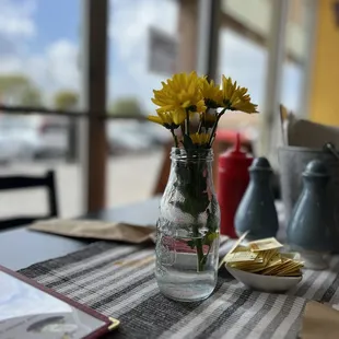 a vase of yellow flowers on a table