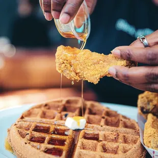 a waffle being drizzled with butter