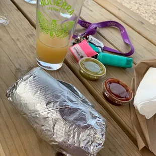 a sandwich and a drink on a picnic table