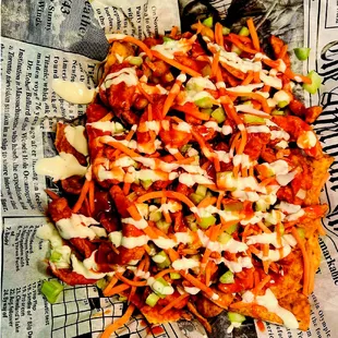 a plate of nachos on a newspaper