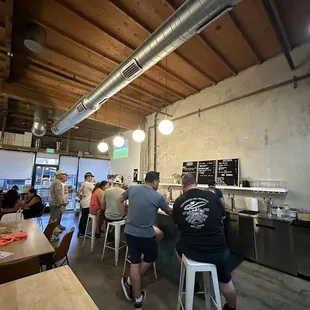 A lot of bar seating and tables in the front and outside