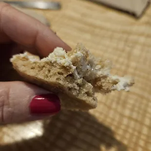 a hand holding a piece of bread