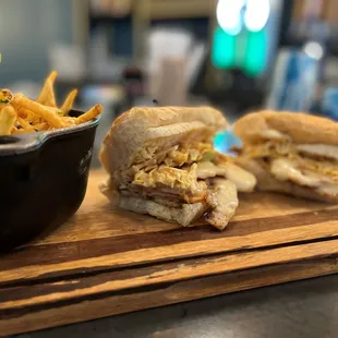 a sandwich and french fries on a cutting board