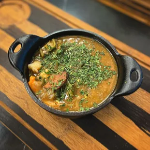 a bowl of stew with a sprig of parsley
