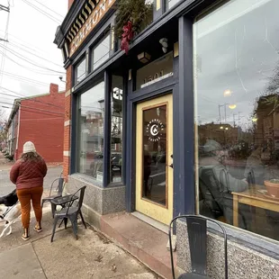 a woman walking her dog on the sidewalk