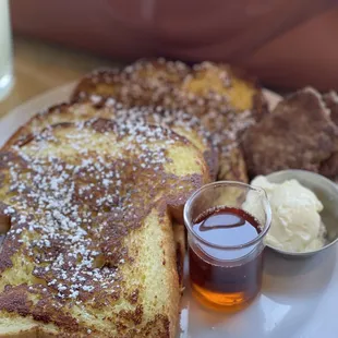 a plate of french toast with butter and syrup
