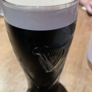 a glass of dark beer on a table