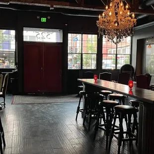 a woman sitting at a bar with a chandelier