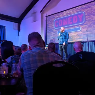 a man standing on stage in front of a crowd