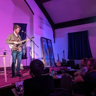 a man playing a guitar on stage