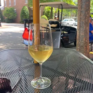 a glass of white wine on a table