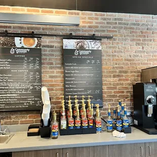 a coffee shop counter with a menu on the wall