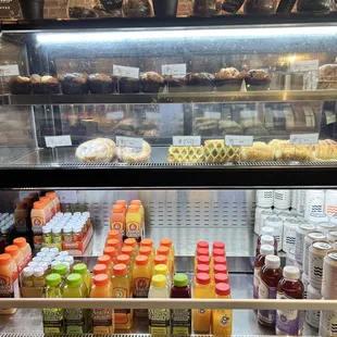 a display case filled with drinks and pastries