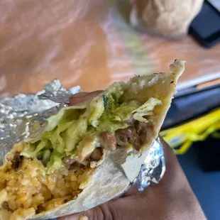 a hand holding a burrito