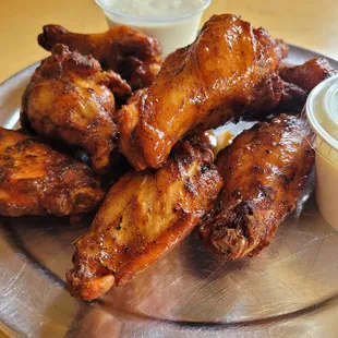 a plate of chicken wings with dipping sauce