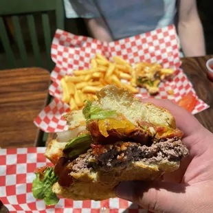 a person holding a sandwich and french fries
