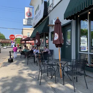 people sitting at tables outside a restaurant