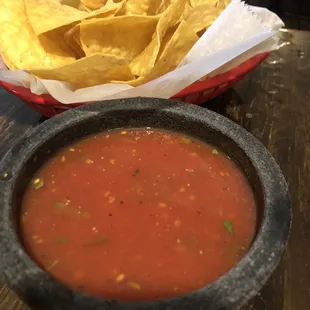 a bowl of salsa and a bowl of tortillas