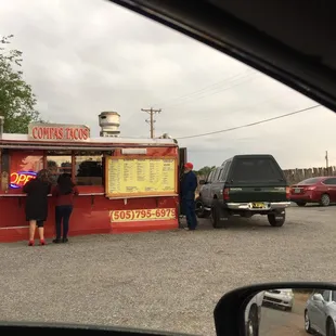 two people standing in front of a food truck