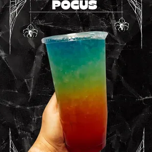 a hand holding a colorful drink