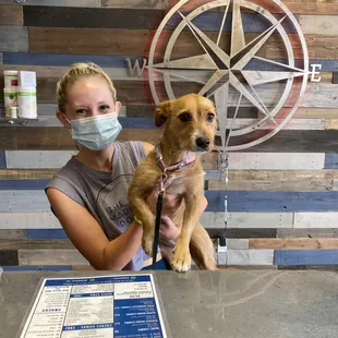 a woman in a face mask holding a dog