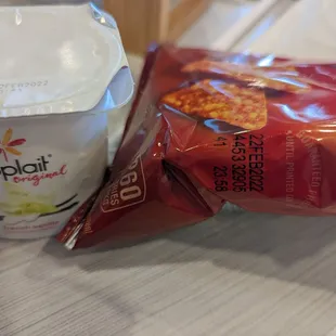 a cup of yogurt and a bag of chips